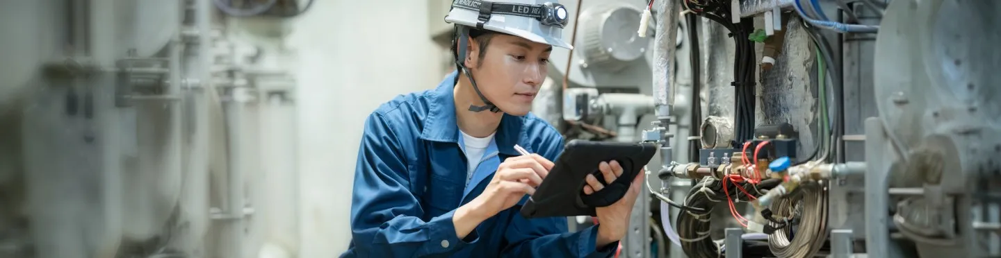 タブレットで設備を点検する技術者
