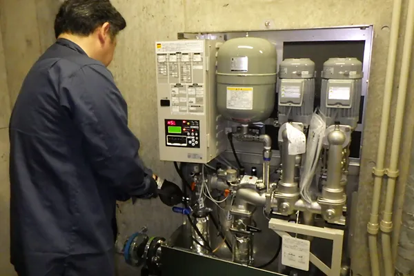 給水ポンプ設備を点検する作業員