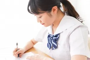 机に向かって勉強する女子学生