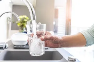 キッチンで浄水をグラスに注ぐ様子